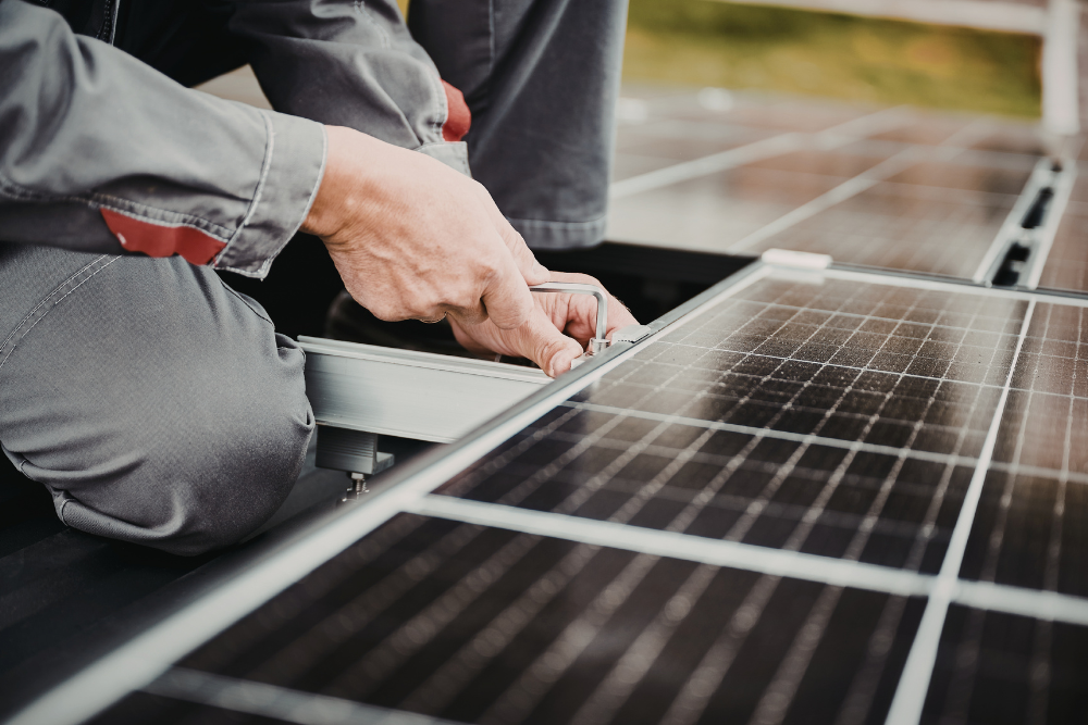 Solar panel installer securing rooftop solar panel mounting brackets on a Central Coast property