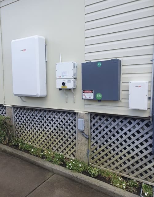 residential solar energy system mounted on a beige siding wall