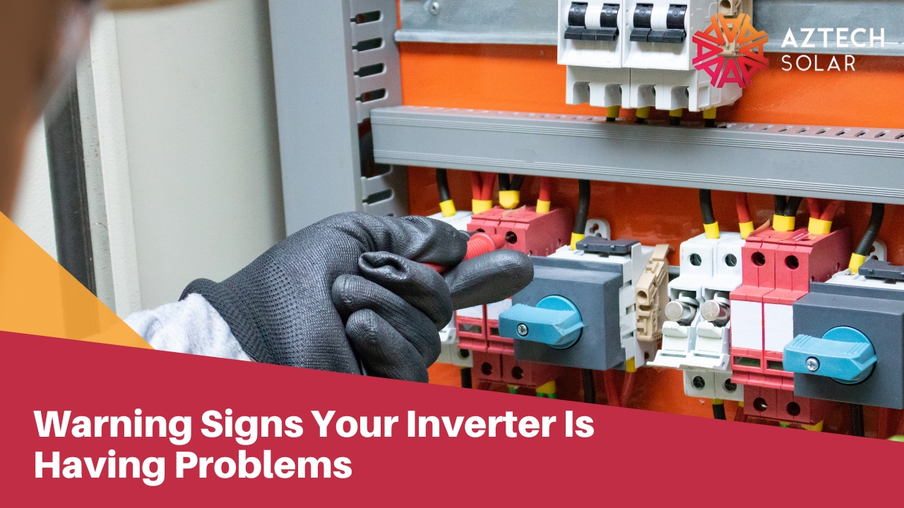 A gloved hand holds a testing probe near switches and wiring inside an electrical panel box.